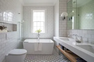 Salle de bain moderne avec baignoire îlot, carrelage métro blanc et sol hexagonal vintage.