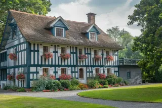 Charmante maison à colombages entourée de verdure, ornée de fleurs colorées aux fenêtres.