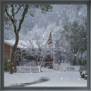 Une maison en bois entourée de neige tombante et d'arbres givrés sous un ciel couvert.