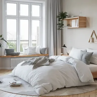 Chambre lumineuse et apaisante avec un grand lit, des coussins confortables et une décoration minimaliste en bois clair.