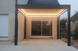 Une pergola moderne avec éclairage intégré se tenant devant une baie vitrée.