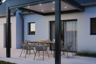 Terrasse moderne avec un toit en pergola illuminé et un ensemble de meubles en rotin autour d'une table dressée.