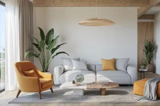 Un salon moderne et épuré avec un canapé gris, un fauteuil jaune, des plantes vertes et une table basse design sous un luminaire en os