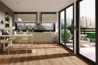 Cuisine moderne avec îlot central, parquet en bois clair et grandes baies vitrées donnant sur un jardin.