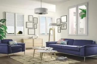 Un salon moderne et lumineux avec des murs blancs, un canapé bleu, des coussins colorés et un mobilier en bois clair, agrémenté de