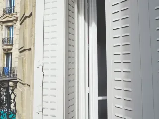 Volet pliant blanc sur balcon pour une façade au style traditionnel